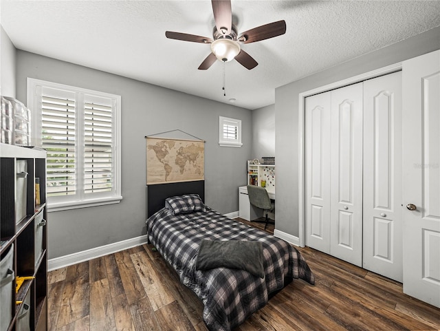 bedroom featuring a closet, a textured ceiling, baseboards, and wood finished floors