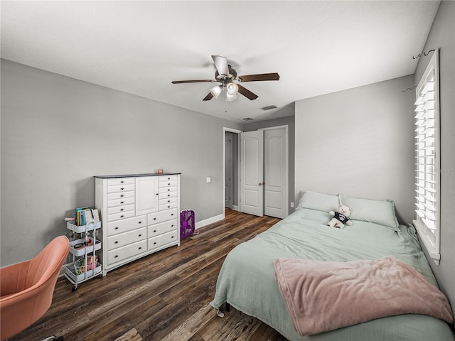 bedroom featuring a ceiling fan, visible vents, wood finished floors, and baseboards