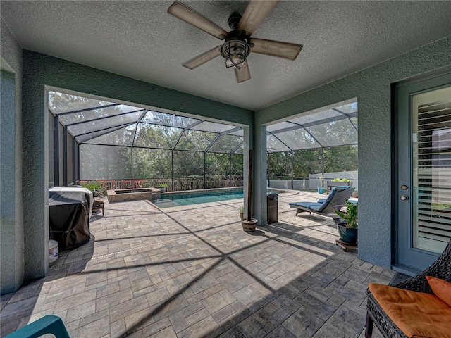 view of patio featuring glass enclosure, a pool with connected hot tub, a ceiling fan, and fence