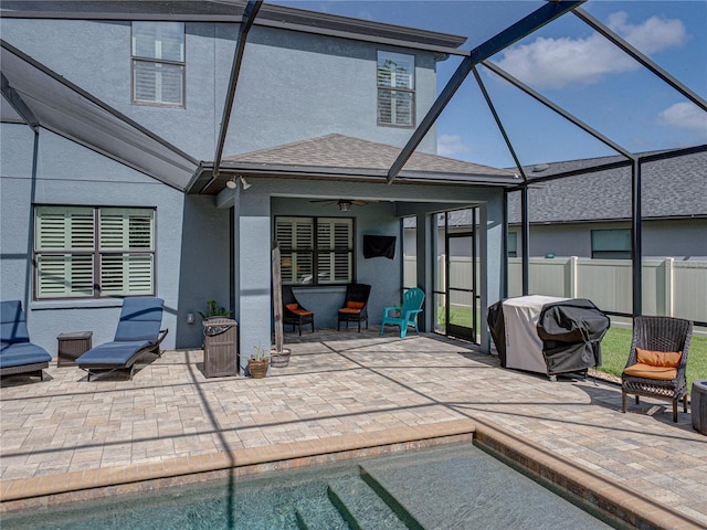 view of swimming pool with ceiling fan, fence, a lanai, area for grilling, and a patio