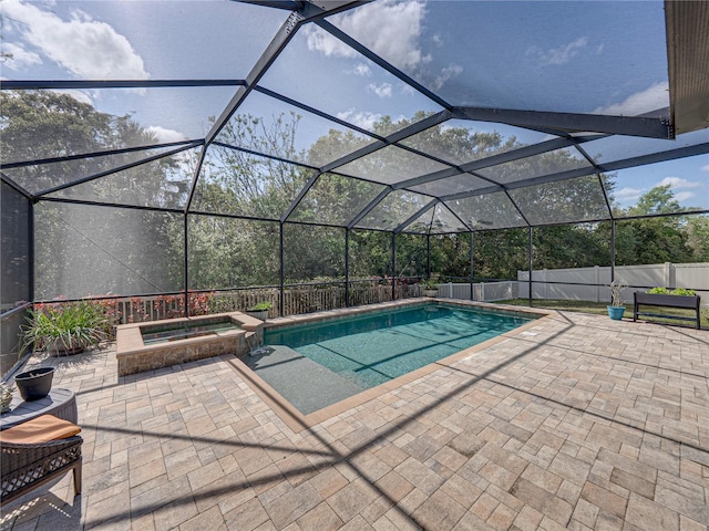 view of swimming pool featuring glass enclosure, a pool with connected hot tub, a patio, and fence