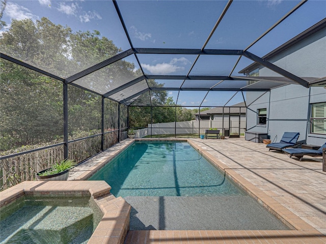 view of swimming pool featuring a patio, fence, a pool with connected hot tub, and a lanai