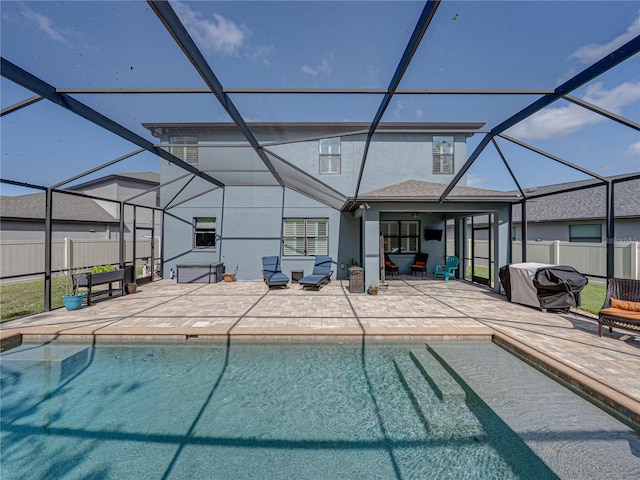 view of swimming pool with a patio area, a lanai, and fence