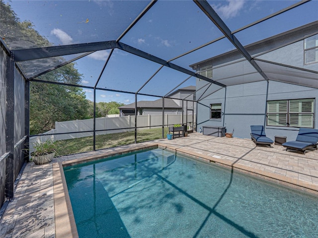 view of swimming pool featuring glass enclosure, a fenced in pool, a patio area, and fence