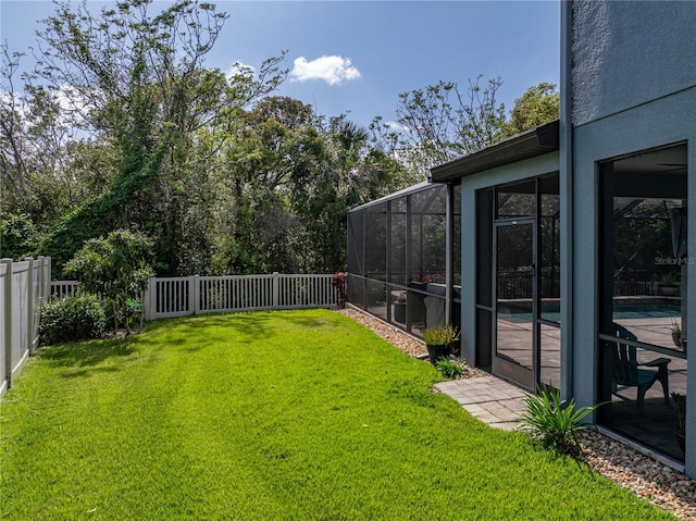 view of yard with glass enclosure and a fenced backyard