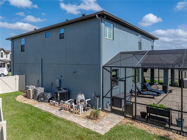 back of house featuring fence, stucco siding, a lawn, a patio area, and a gate