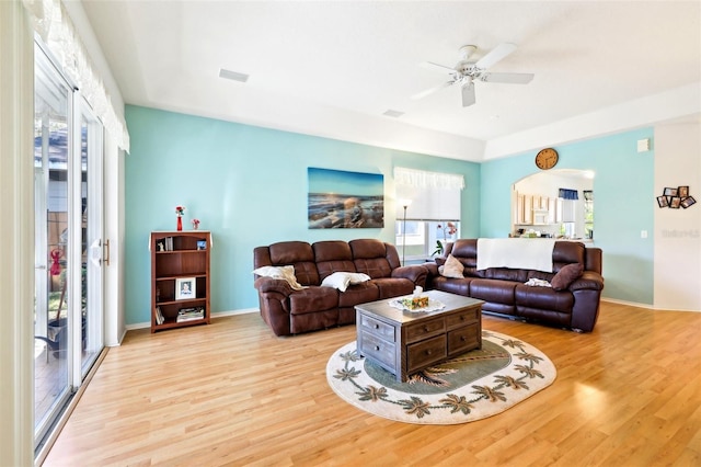 living area featuring ceiling fan, baseboards, and wood finished floors