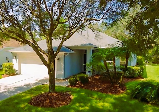 ranch-style house with stucco siding, a front yard, concrete driveway, and an attached garage