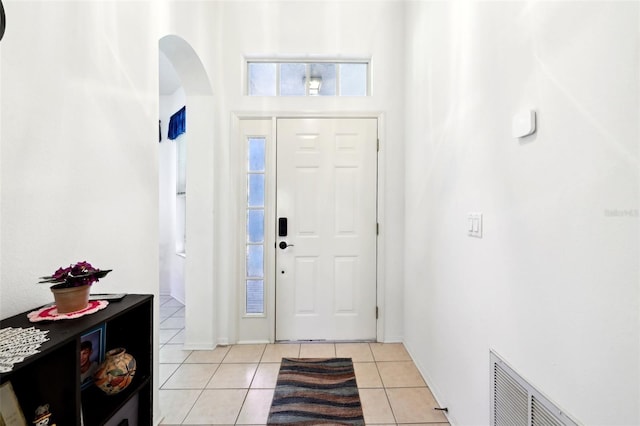 entrance foyer featuring light tile patterned flooring, visible vents, and arched walkways