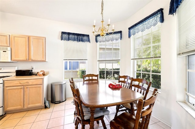 dining space with a wealth of natural light, light tile patterned floors, and an inviting chandelier