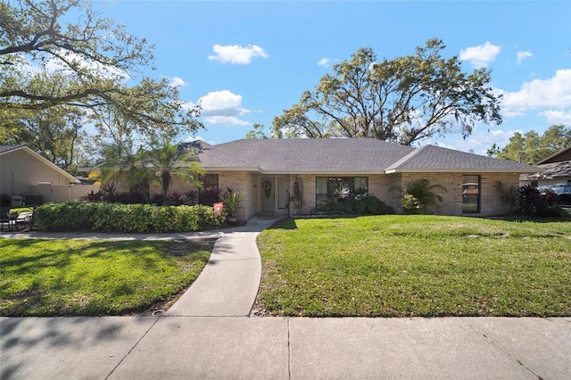 ranch-style house featuring brick siding and a front yard