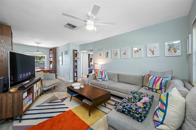 living area featuring visible vents, ceiling fan, and wood finished floors