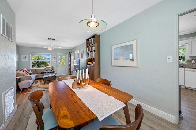 dining room featuring visible vents, light wood-style flooring, and baseboards