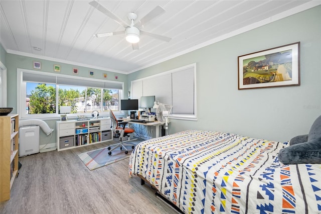 bedroom featuring crown molding, a ceiling fan, and wood finished floors