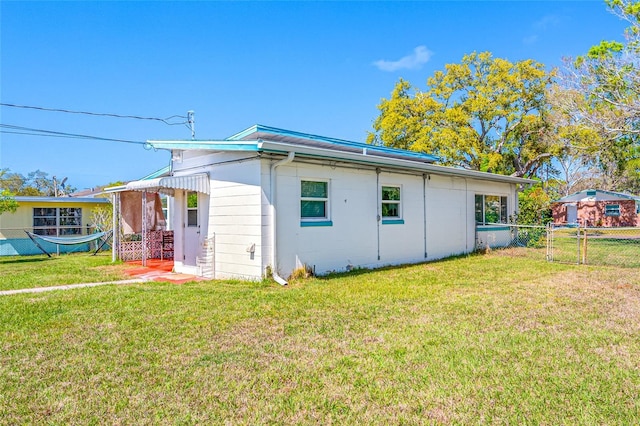 view of home's exterior with a lawn and fence