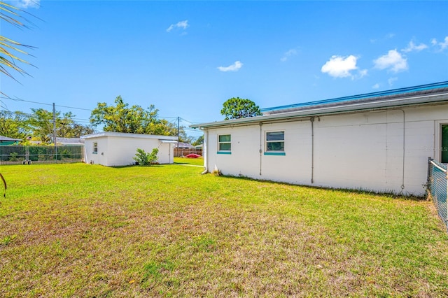 view of yard with an outbuilding and fence