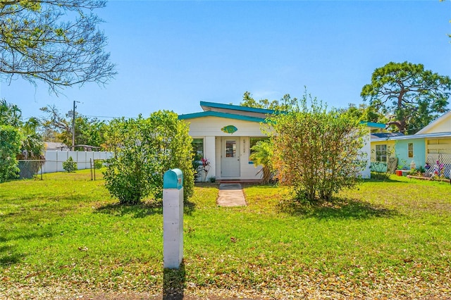 view of front of home with a front yard and fence