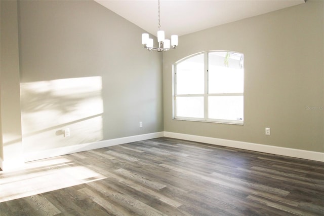 spare room featuring baseboards, lofted ceiling, a chandelier, and dark wood-style flooring