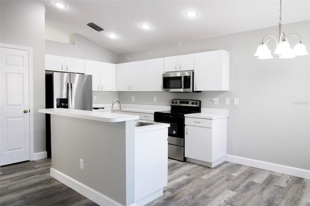 kitchen featuring visible vents, appliances with stainless steel finishes, light wood finished floors, lofted ceiling, and light countertops