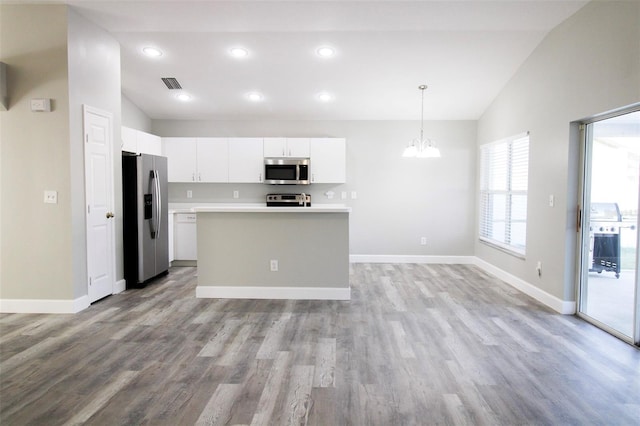 kitchen with visible vents, white cabinetry, stainless steel appliances, light countertops, and vaulted ceiling