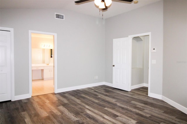 unfurnished bedroom with visible vents, baseboards, dark wood-type flooring, and lofted ceiling