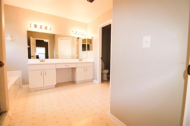 full bathroom with baseboards, toilet, a garden tub, tile patterned floors, and vanity