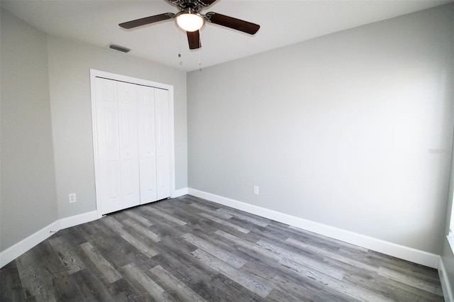 unfurnished bedroom with a ceiling fan, visible vents, baseboards, dark wood finished floors, and a closet