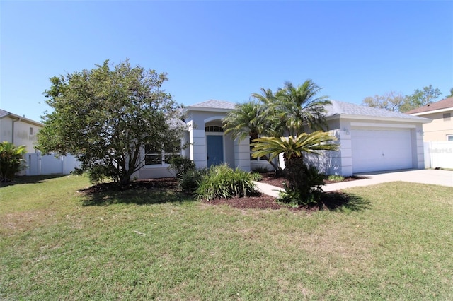 view of front of home featuring a front yard, fence, driveway, an attached garage, and stucco siding