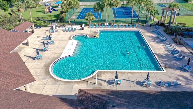 pool with a patio and fence