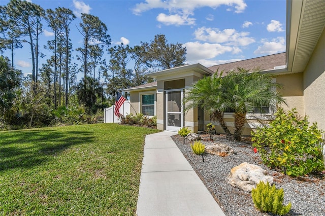 doorway to property with stucco siding and a yard