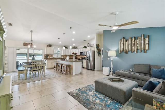 living room with visible vents, vaulted ceiling, light tile patterned floors, ceiling fan with notable chandelier, and recessed lighting