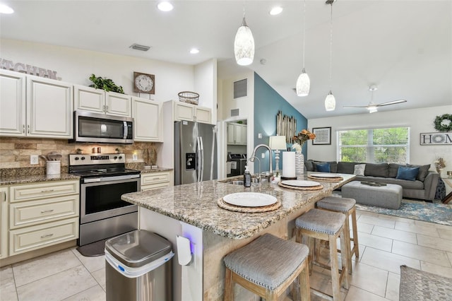 kitchen featuring a sink, stainless steel appliances, open floor plan, and light tile patterned flooring