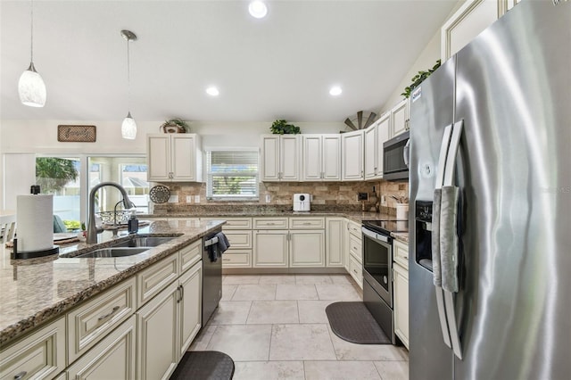 kitchen with tasteful backsplash, light stone counters, appliances with stainless steel finishes, hanging light fixtures, and a sink