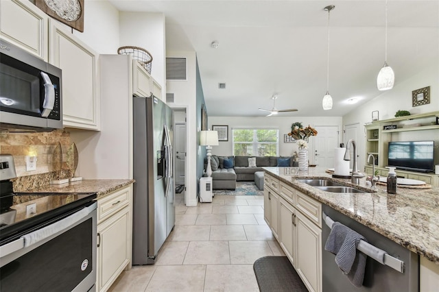 kitchen featuring visible vents, open floor plan, decorative backsplash, appliances with stainless steel finishes, and a sink