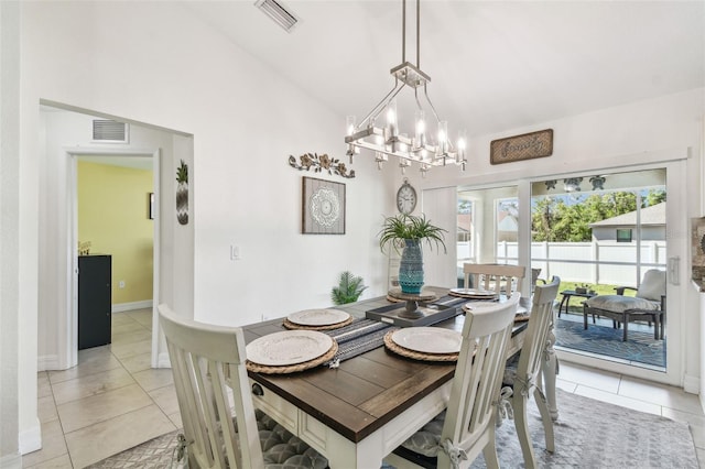 dining space with light tile patterned floors, visible vents, and vaulted ceiling