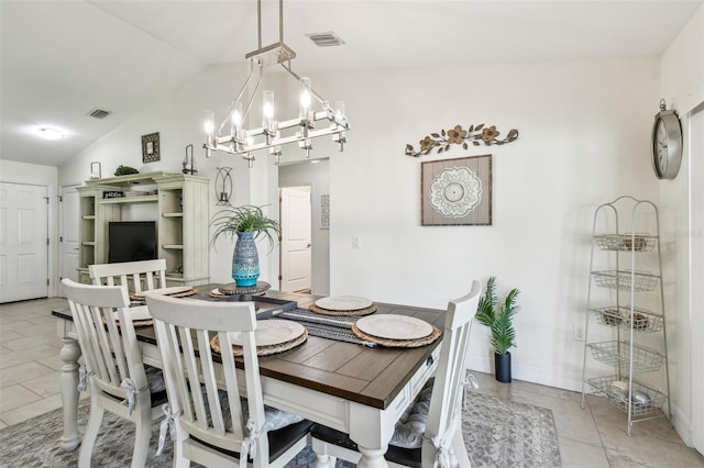 dining room with a notable chandelier, visible vents, light tile patterned floors, and vaulted ceiling