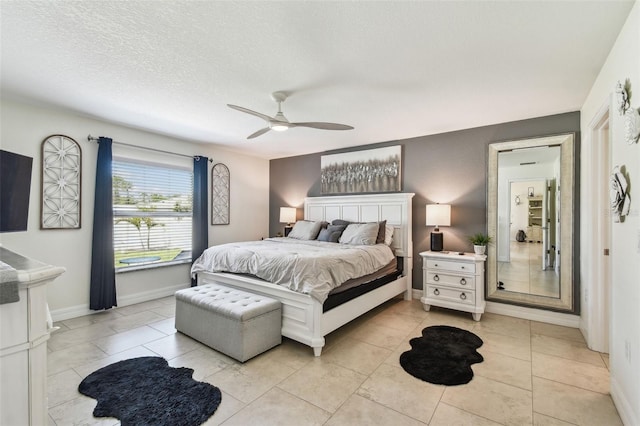 bedroom with light tile patterned floors, baseboards, a textured ceiling, and a ceiling fan