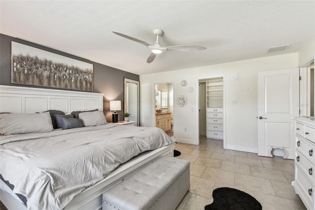 bedroom featuring baseboards, a ceiling fan, visible vents, and connected bathroom