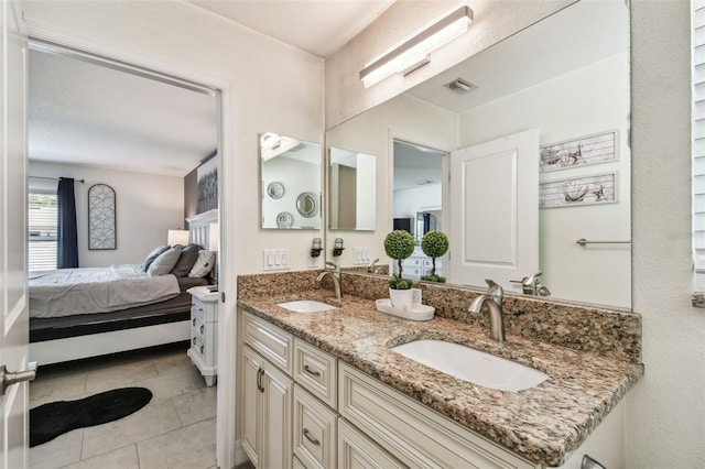 ensuite bathroom featuring double vanity, tile patterned flooring, ensuite bath, and a sink