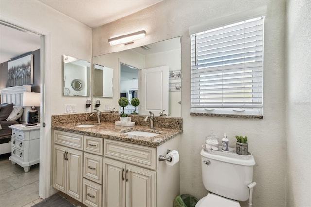 full bath featuring double vanity, toilet, and a sink