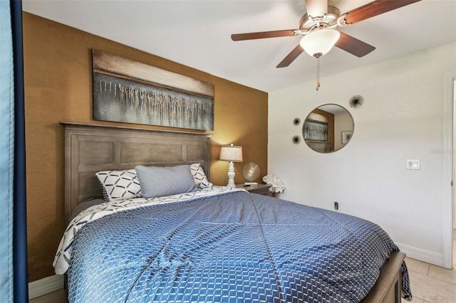 tiled bedroom with ceiling fan and baseboards