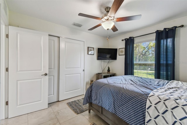 bedroom featuring visible vents, a closet, light tile patterned flooring, and a ceiling fan