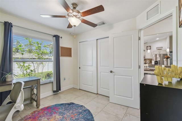 office area featuring light tile patterned floors, visible vents, baseboards, and a ceiling fan