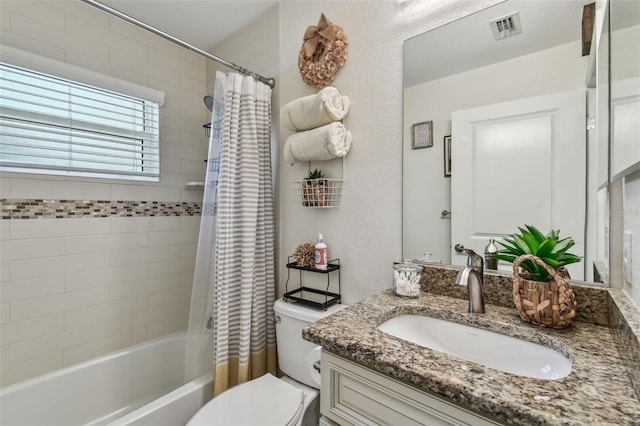 bathroom featuring visible vents, shower / bath combo with shower curtain, toilet, and vanity