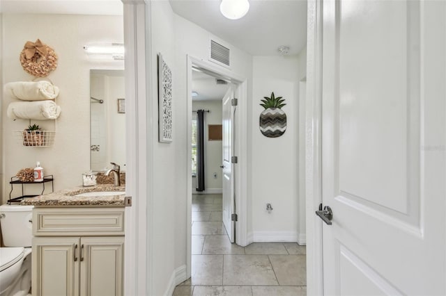 bathroom with vanity, baseboards, visible vents, tile patterned floors, and toilet