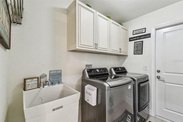 laundry area featuring a sink, cabinet space, and washer and clothes dryer