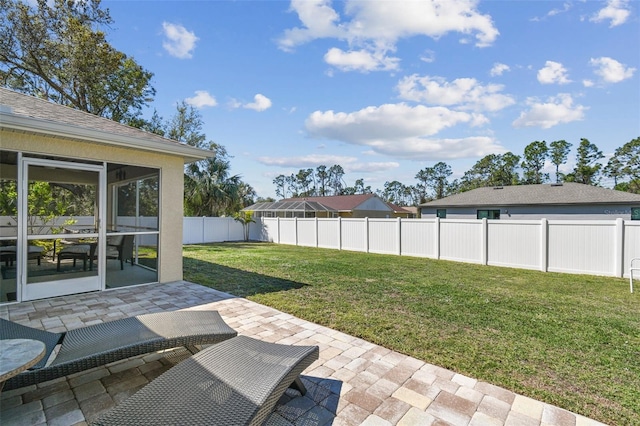 view of yard with a sunroom, a fenced backyard, and a patio area