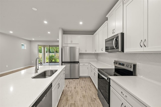 20405 Symphony Pl, Venice, FL 34293 - kitchen with white cabinets, a sink, light countertops, recessed lighting, and stainless steel appliances