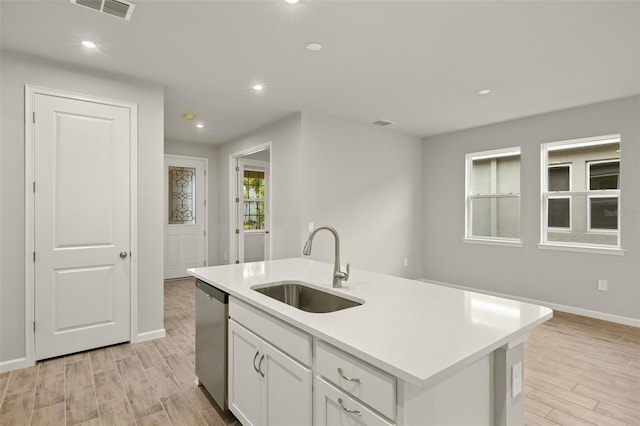 20405 Symphony Pl, Venice, FL 34293 - kitchen with visible vents, white cabinets, a sink, light wood-type flooring, and stainless steel dishwasher