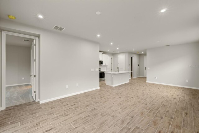 20405 Symphony Pl, Venice, FL 34293 - unfurnished living room featuring light wood-style flooring, visible vents, and recessed lighting